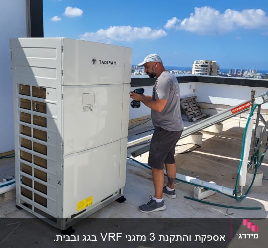 אדם מתקין מזגן תדיראן על גג בניין